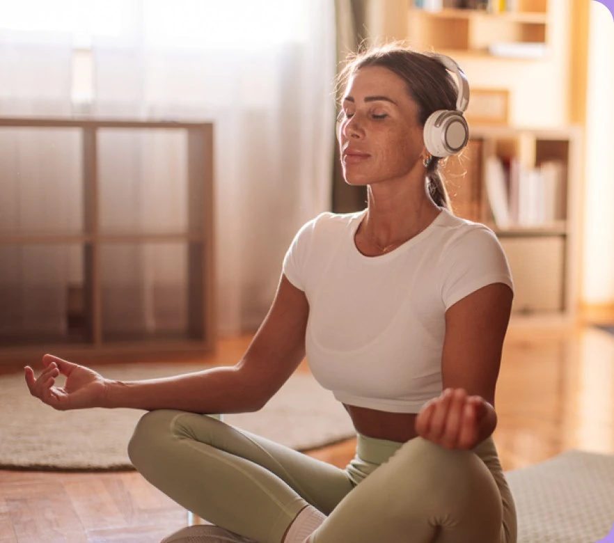 Žena meditira na podu dnevne sobe